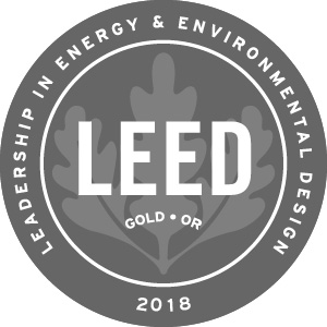 LEED 2018 GOLD Logo. Grey emblem with white writing.